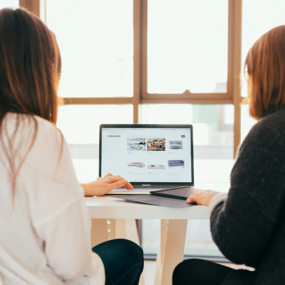 Deux femmes parlant stratégie digitale devant un ordinateur