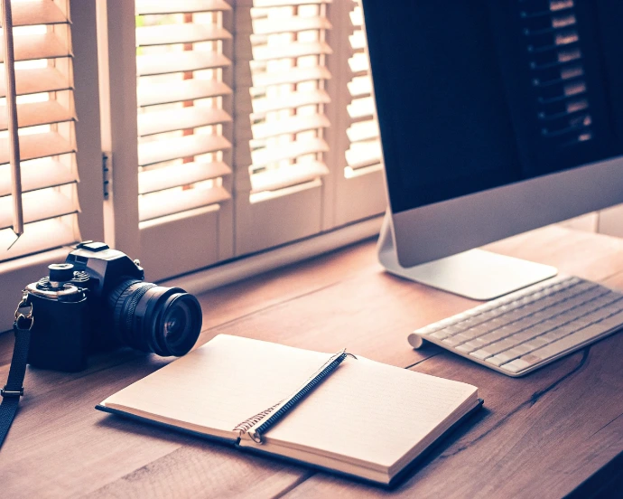 Espace de travail de vidéaste de mariage avec caméra et station de montage, illustrant le temps nécessaire pour livrer un film de qualité