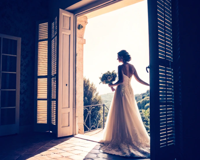 Mariée debout face à la lumière, symbole de la confiance et du lien humain essentiel avec son vidéaste de mariage