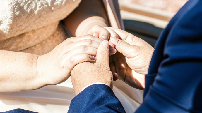 Mains des mariés se tenant lors de la cérémonie, symbole d’un engagement capté dans sa forme la plus essentielle